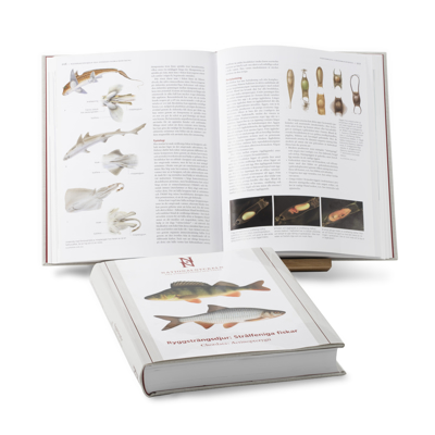 En uppslagen bok med fiskar och en hopslagen bok med fiskmotiv